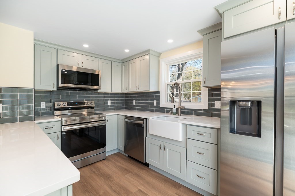 32 Lexington Drive Beverly, MA 01915 - Photo 3 of 41 a kitchen with stainless steel appliances granite countertop a stove top oven a sink dishwasher a refrigerator and a microwave oven with wooden floor