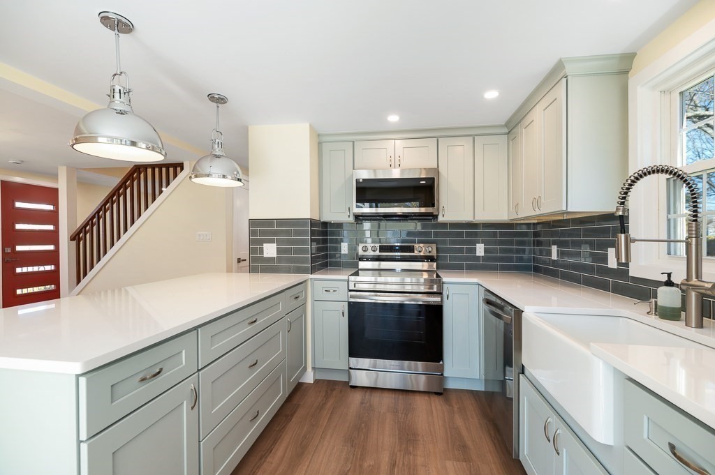 32 Lexington Drive Beverly, MA 01915 - Photo 4 of 41 a kitchen with stainless steel appliances granite countertop a sink a stove and a refrigerator
