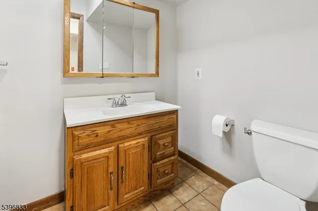 a bathroom with a sink mirror vanity and toilet