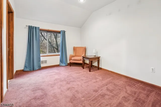 an empty room with windows and lounge chair