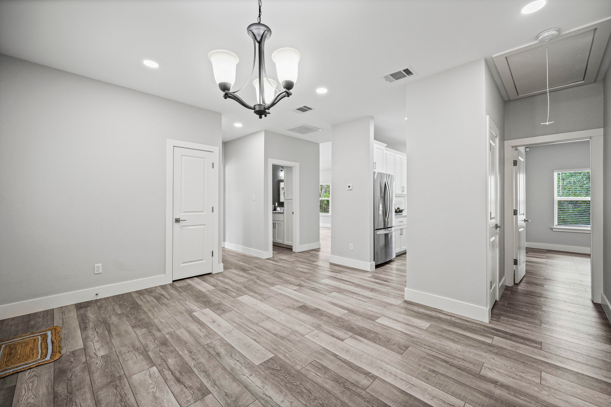 231 North Rainbow Ranch Road Wimberley, TX 78676 - Photo 9 of 40 A graceful chandelier illuminates the seamless flow of this open-concept interior.