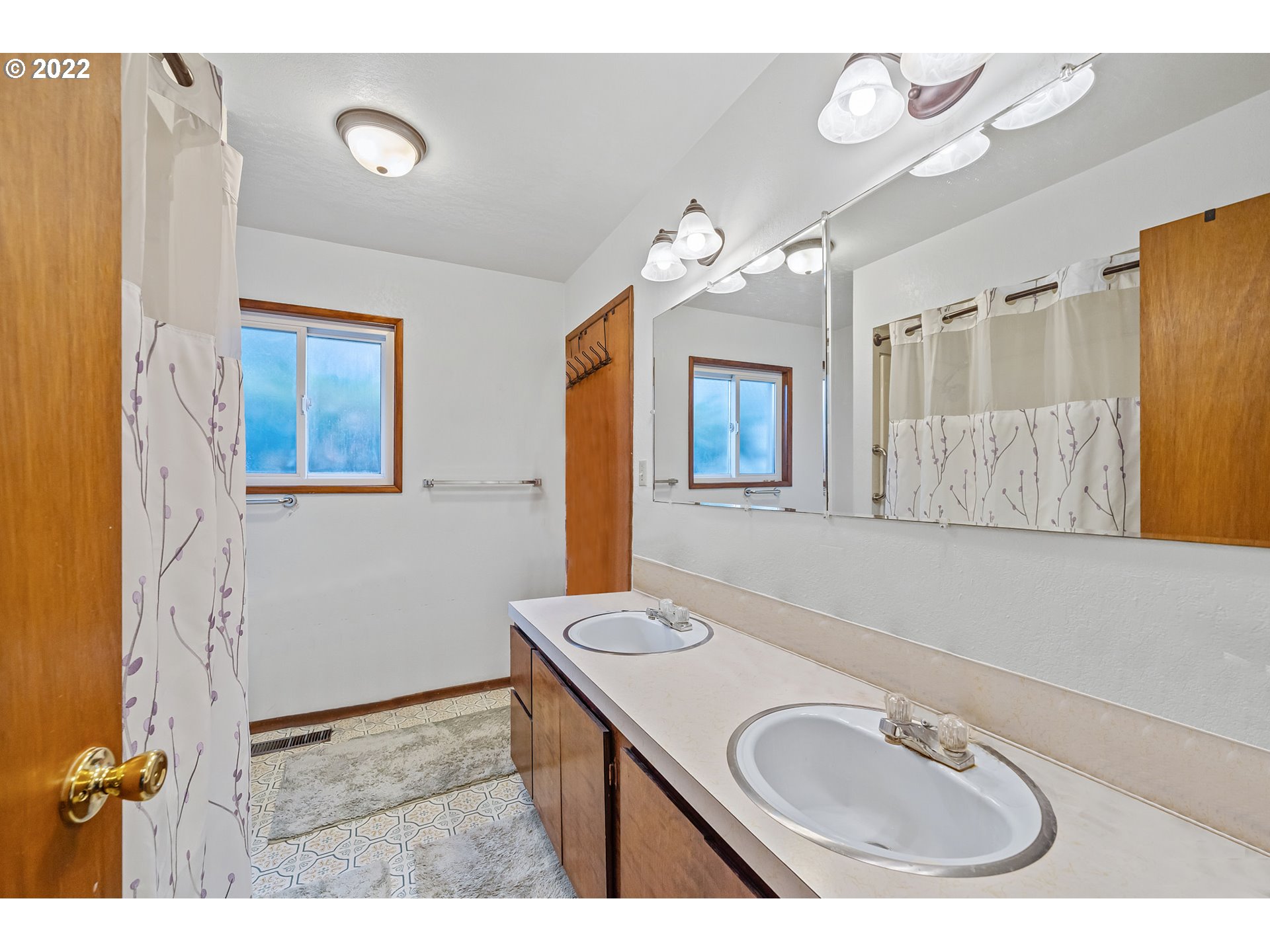 8020 Greentree Ridge Road Tillamook, OR 97141 - Photo 11 of 31 a bathroom with a sink a two mirror a bathtub and a window