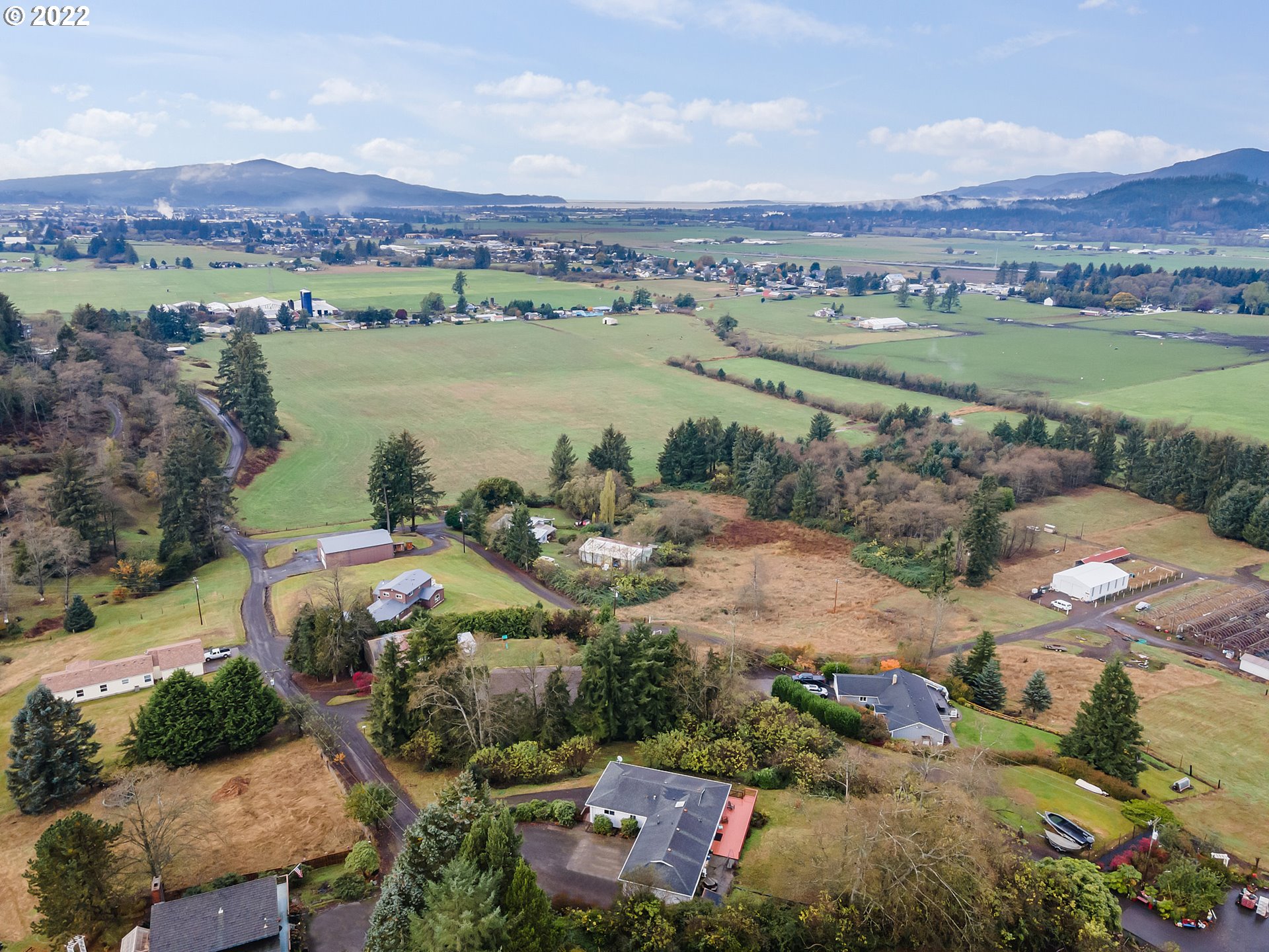 8020 Greentree Ridge Road Tillamook, OR 97141 - Photo 4 of 31 an aerial view of a city with lots of residential buildings and mountain view in back