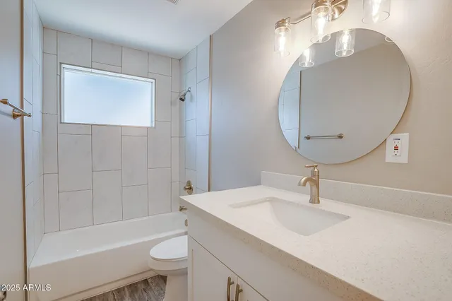 an empty room with wooden floor a ceiling fan and windows