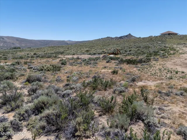 a view of a field with mountains in the background
