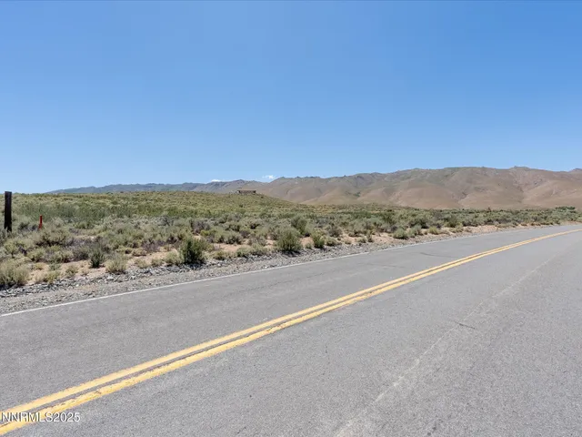 a view of a dry yard with mountains in the background