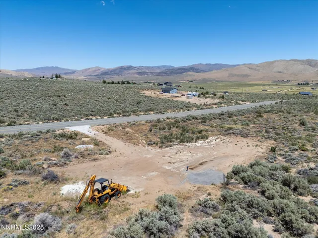 a view of a dirt field with mountains in the background