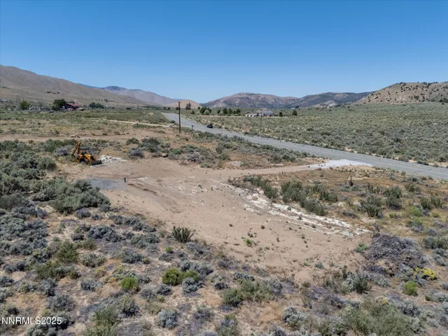 a view of a dry field with mountains in the background