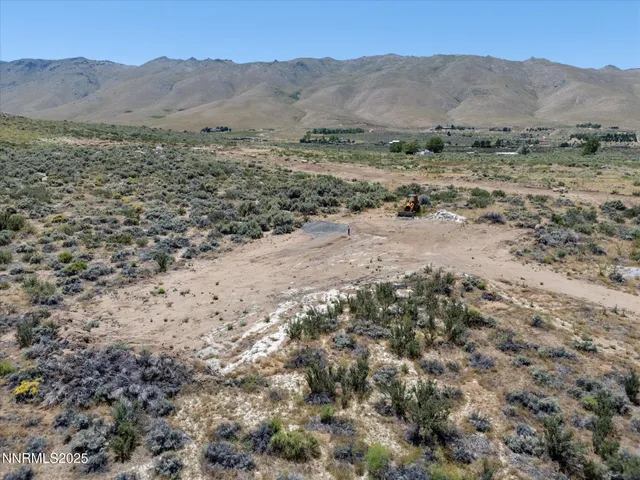 a view of a dry yard with mountains in the background