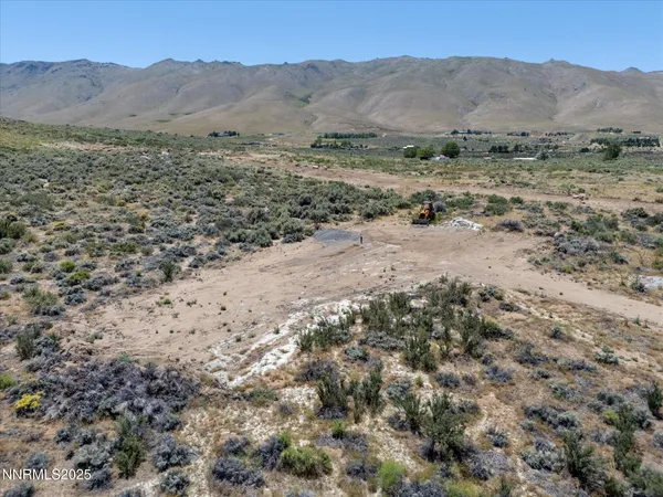 a view of a dry yard with mountains in the background