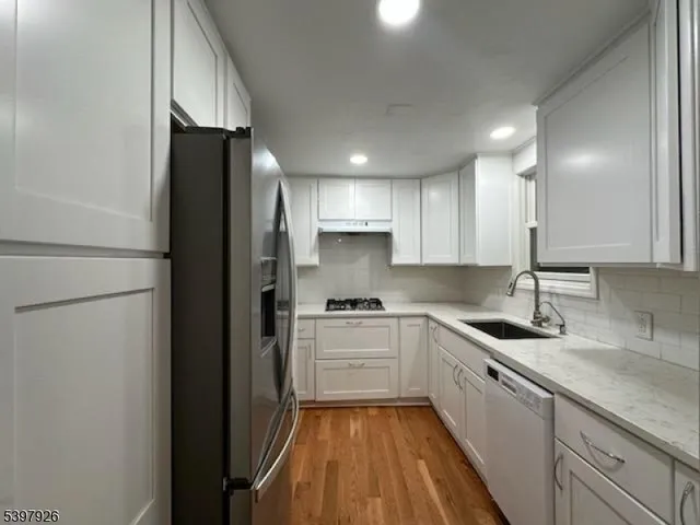 a kitchen with a sink a refrigerator and cabinets