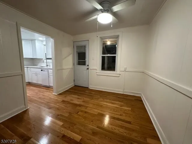 a view of an empty room with a kitchen and a window