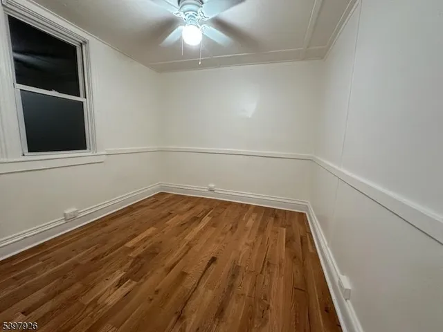 a view of a room with wooden floor and fan