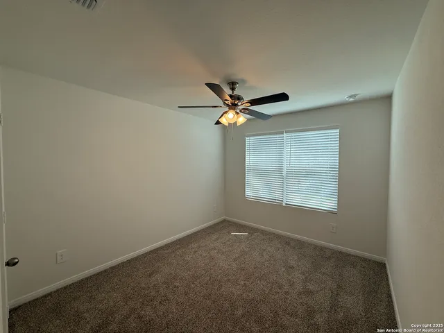 a view of a livingroom with a ceiling fan and window