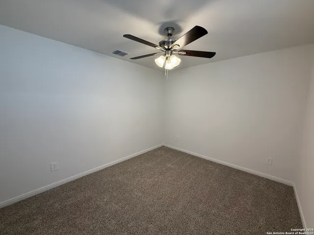 an empty room with chandelier fan