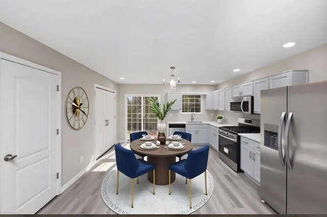 a kitchen with stainless steel appliances granite countertop a stove a refrigerator a sink a dining table and chairs with wooden floor