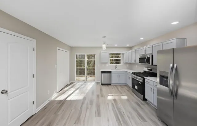 a kitchen with granite countertop a stove top oven and refrigerator