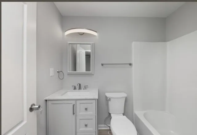 a bathroom with a toilet sink and mirror