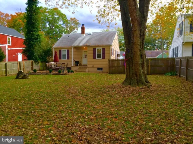 a front view of a house with a garden and tree