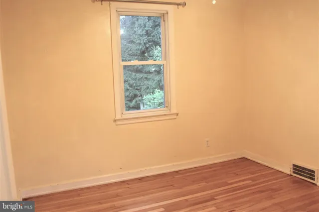 a view of a small space with wooden floor and a window