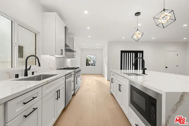 a large kitchen with stainless steel appliances kitchen island a large counter tops and a view of living room