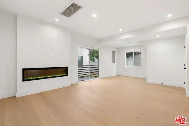 a view of an empty room with a fireplace and a window