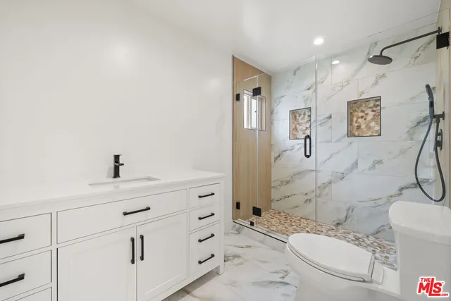 a bathroom with a sink toilet vanity and shower