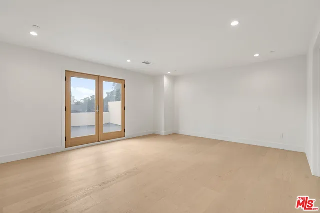 an empty room with sliding glass door and windows