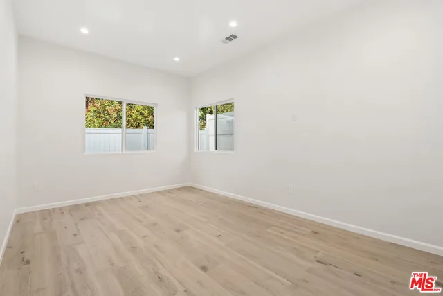 an empty room with wooden floor and a window