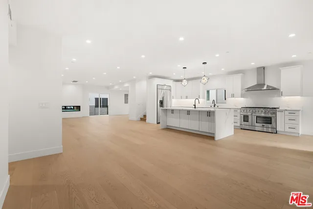 a view of kitchen with kitchen island and stainless steel appliances