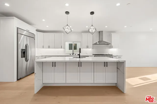 a kitchen with kitchen island granite countertop a sink a counter space stainless steel appliances and cabinets