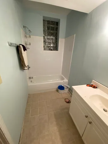 a bedroom with a bed and a lamp with the dresser