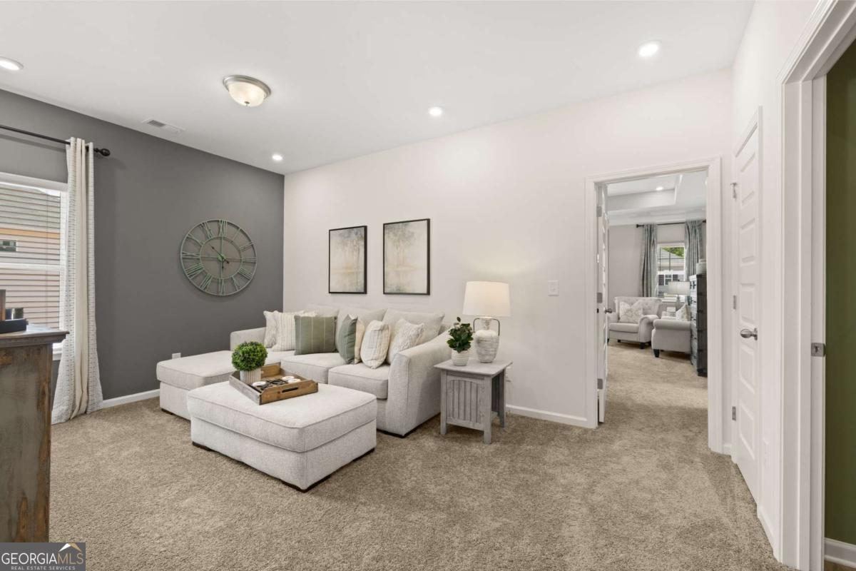 1416 Trellis Court, Unit (LOT 21) Hampton, GA 30228 - Photo 20 of 27 a living room with furniture and a clock