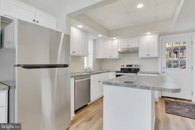 a kitchen with stainless steel appliances granite countertop refrigerator sink and cabinets