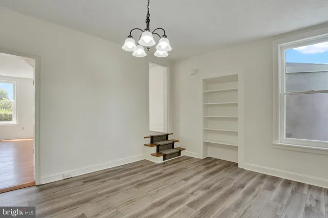 a view of a room with wooden floor and windows