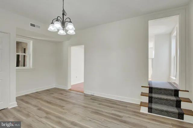 a view of a livingroom with wooden floor and a large window