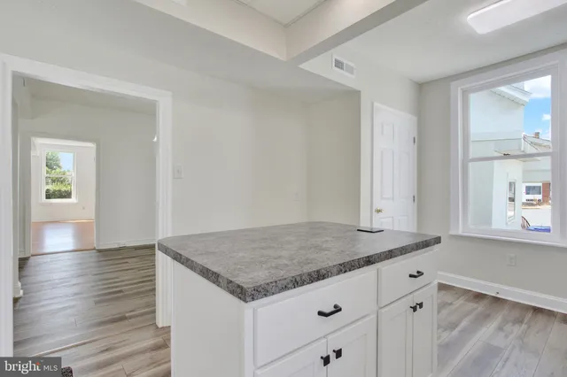 a view of a kitchen island wooden floor and hallway