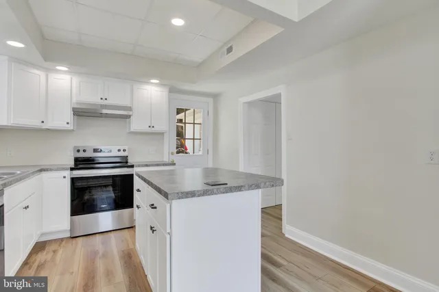 a kitchen with stainless steel appliances granite countertop a stove a sink and a refrigerator