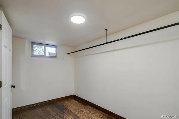 a view of a room with wooden floor and small window