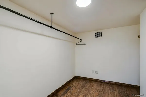 a view of a small space with wooden floor and a window