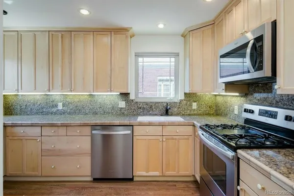 a kitchen with stainless steel appliances granite countertop a stove and a microwave
