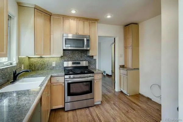 a kitchen with stainless steel appliances granite countertop a stove a refrigerator and a sink