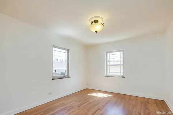 an empty room with windows and flowerpot