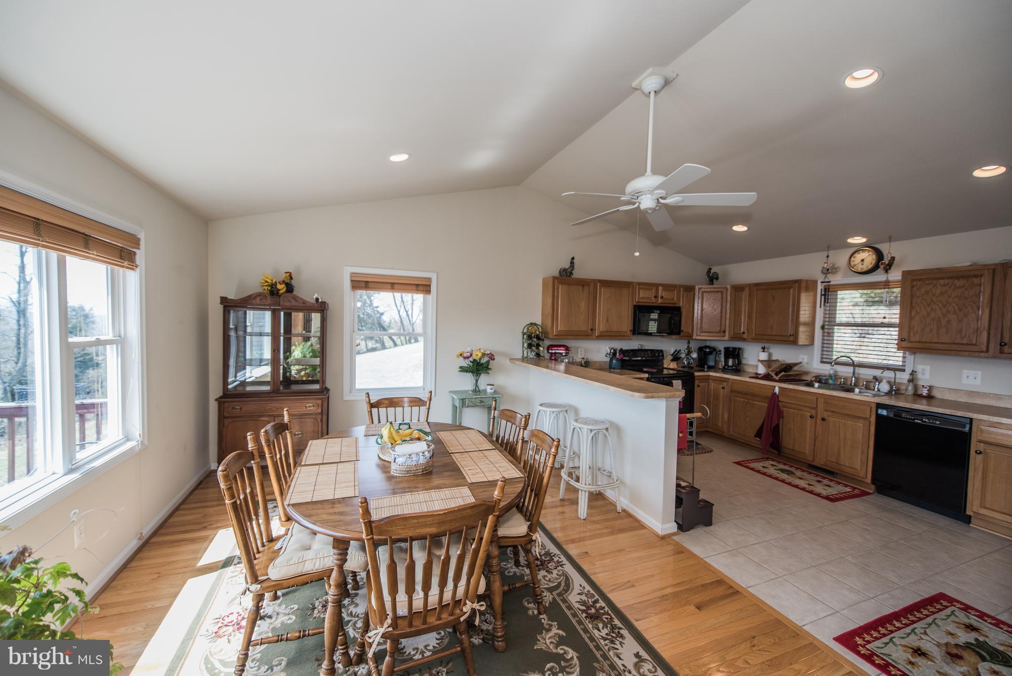 964 Granny Smith Road Linden, VA 22642 - Photo 12 of 30 a kitchen with stainless steel appliances granite countertop a stove top oven a sink dishwasher a dining table and chairs with wooden floor
