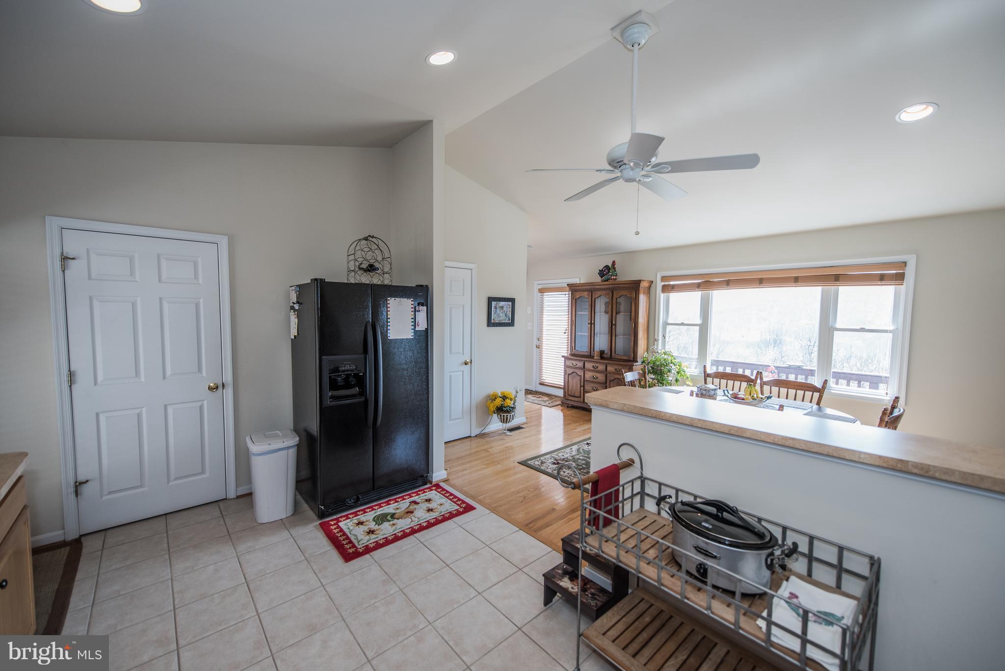 964 Granny Smith Road Linden, VA 22642 - Photo 17 of 30 a kitchen with a refrigerator a stove a sink and a dining table with white walls