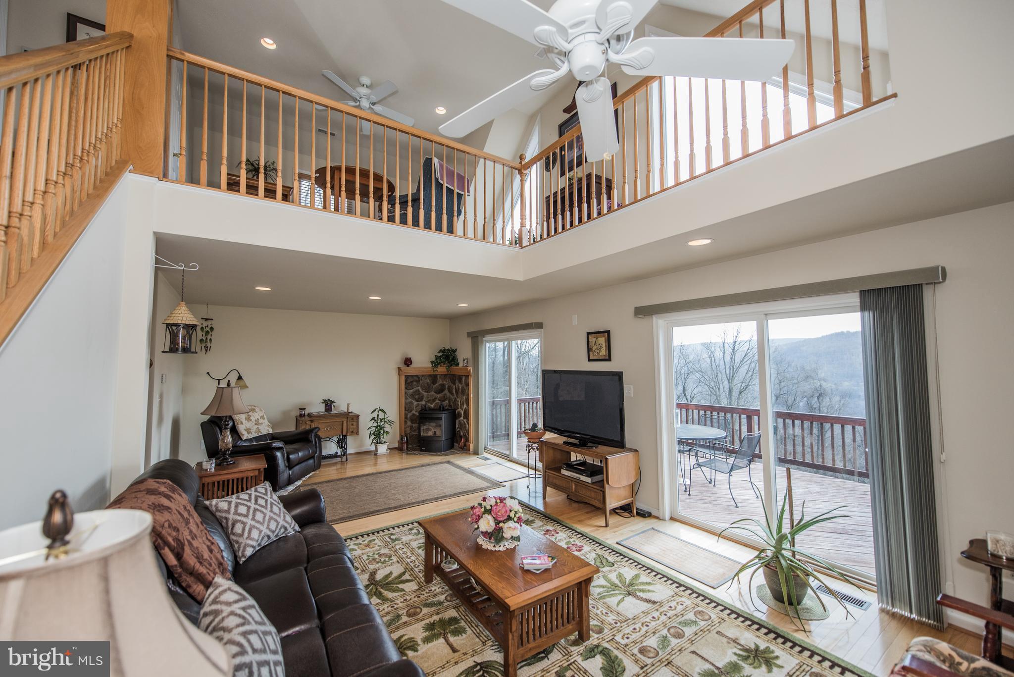 964 Granny Smith Road Linden, VA 22642 - Photo 8 of 30 a living room with furniture a flat screen tv and a floor to ceiling window