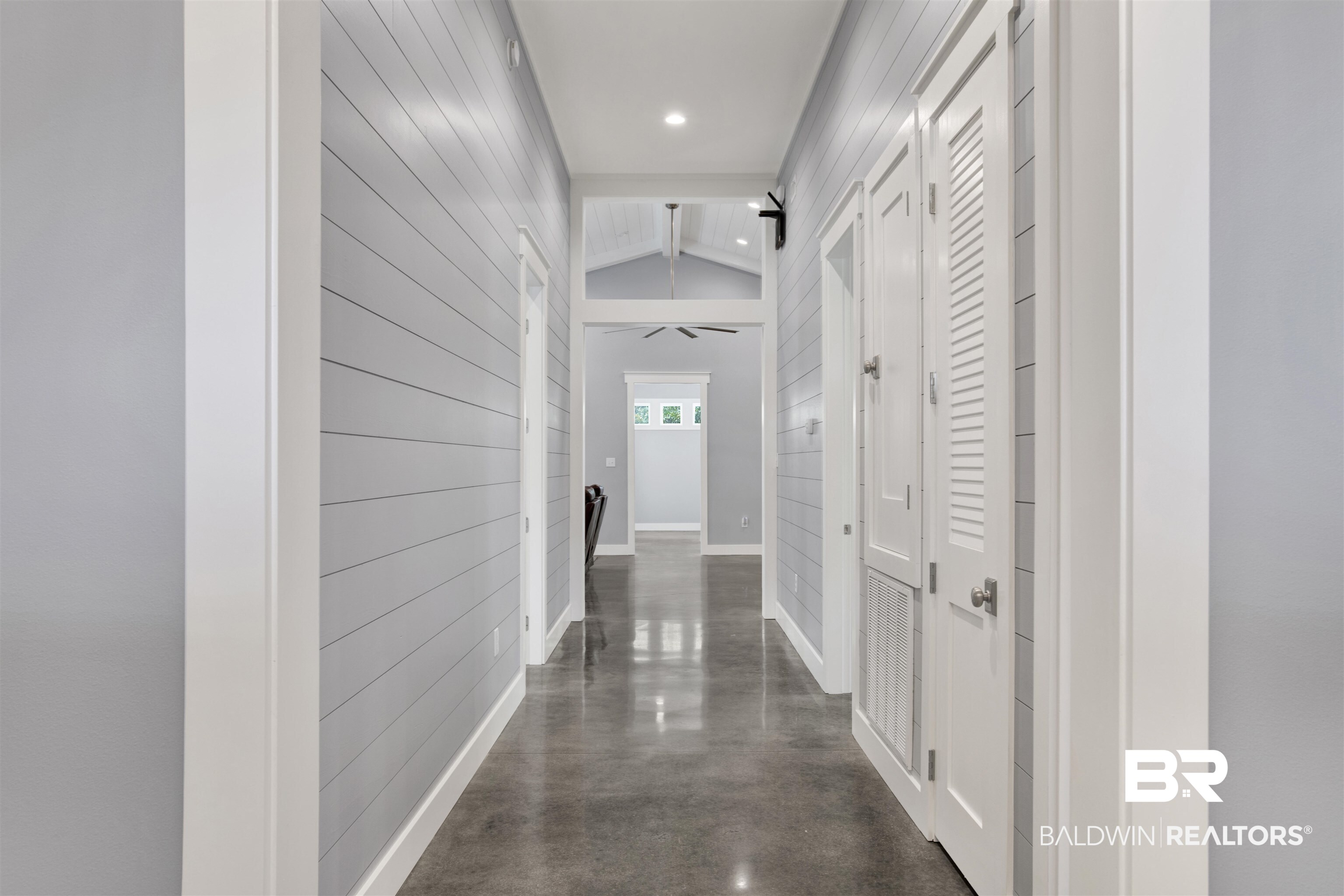 27980 Canal Road Orange Beach, AL 36561 - Photo 18 of 46 Corridor with lofted ceiling, wood walls, concrete flooring, and recessed lighting