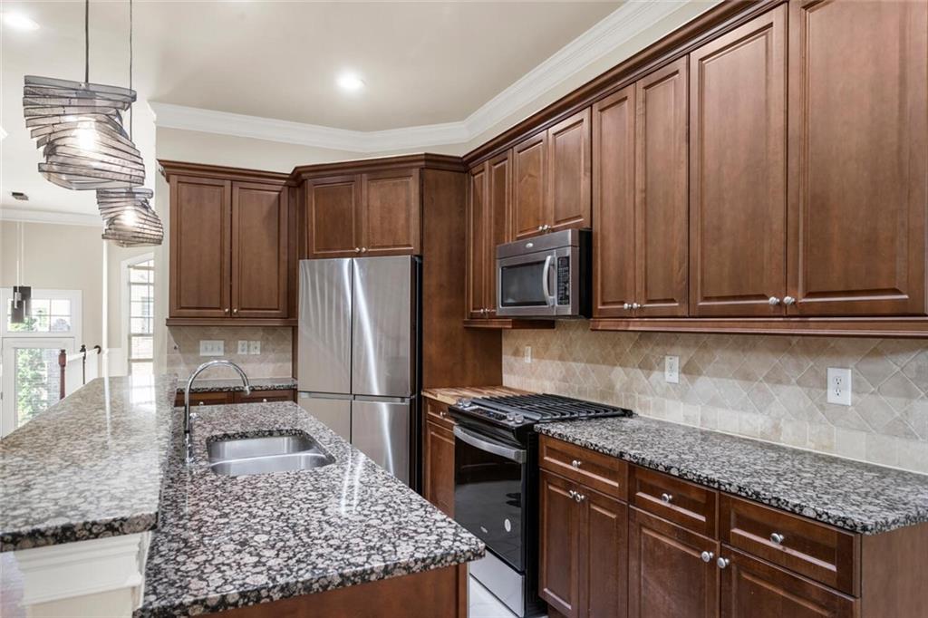 2663 Rivers Edge Drive Northeast Brookhaven, GA 30324 - Photo 11 of 37 a kitchen with kitchen island granite countertop wooden cabinets and a stove top oven