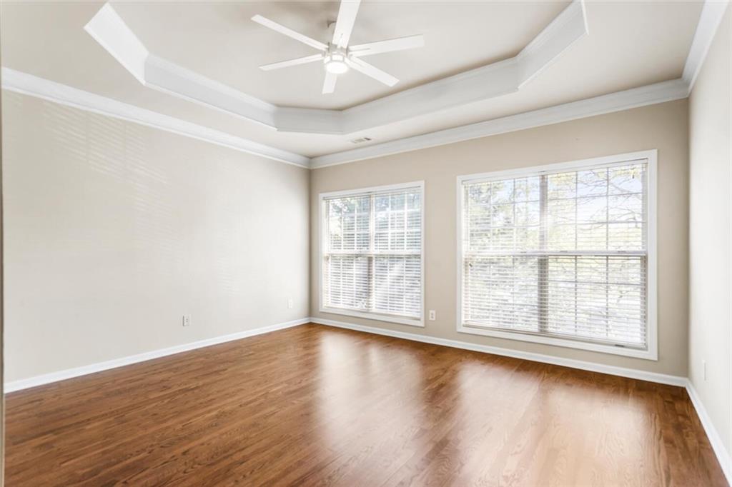 2663 Rivers Edge Drive Northeast Brookhaven, GA 30324 - Photo 21 of 37 an empty room with wooden floor and windows with curtains