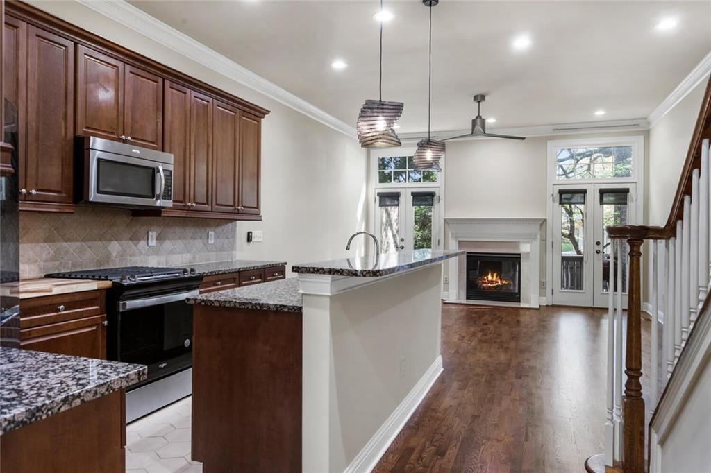 2663 Rivers Edge Drive Northeast Brookhaven, GA 30324 - Photo 8 of 37 a kitchen with stainless steel appliances granite countertop a refrigerator a stove top oven a sink dishwasher and a fireplace with wooden floor